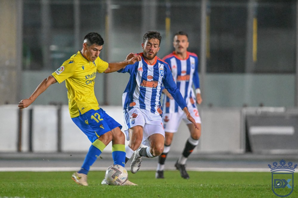 A Cádiz CF player shields the ball from an opponent