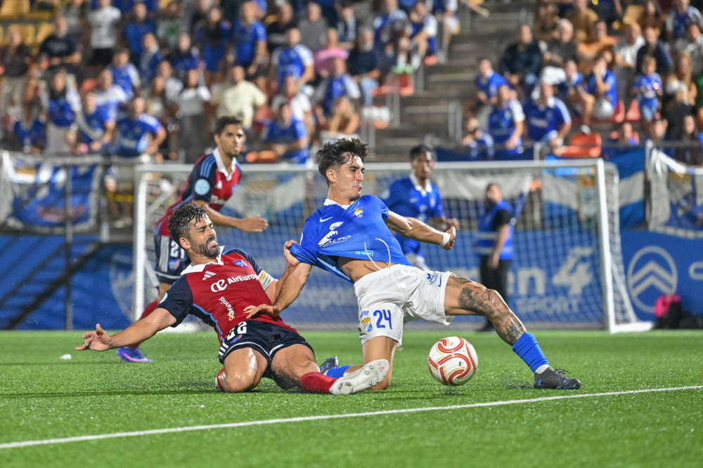 A Xerez CD player battles for the ball with an opponent inside the area