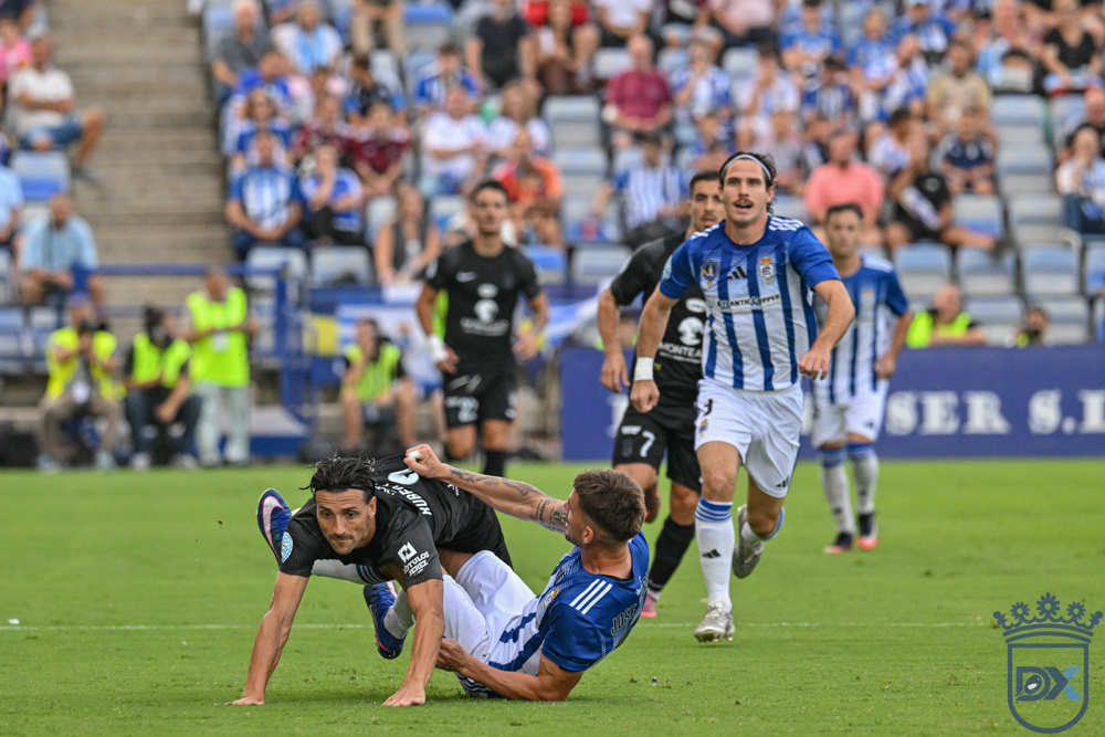 A Xerez CD player falls to the turf after a challenge with a Recreativo de Huelva player