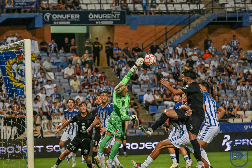 Jero Lario punches clear a high ball under pressure from Xerez CD players at the Nuevo Colombino