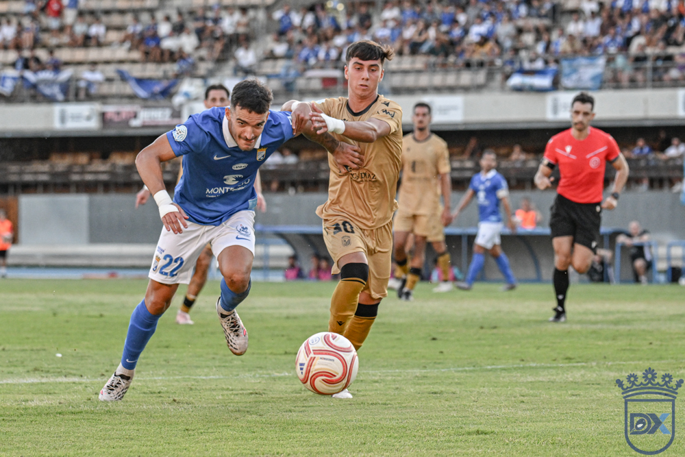 A Xerez CD player battles for the ball with a CD Badajoz opponent at Chapín
