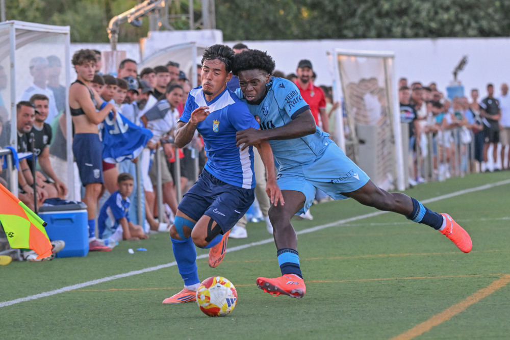 Jugador del Xerez CD conduce el balón perseguido por un rival del Ceuta B