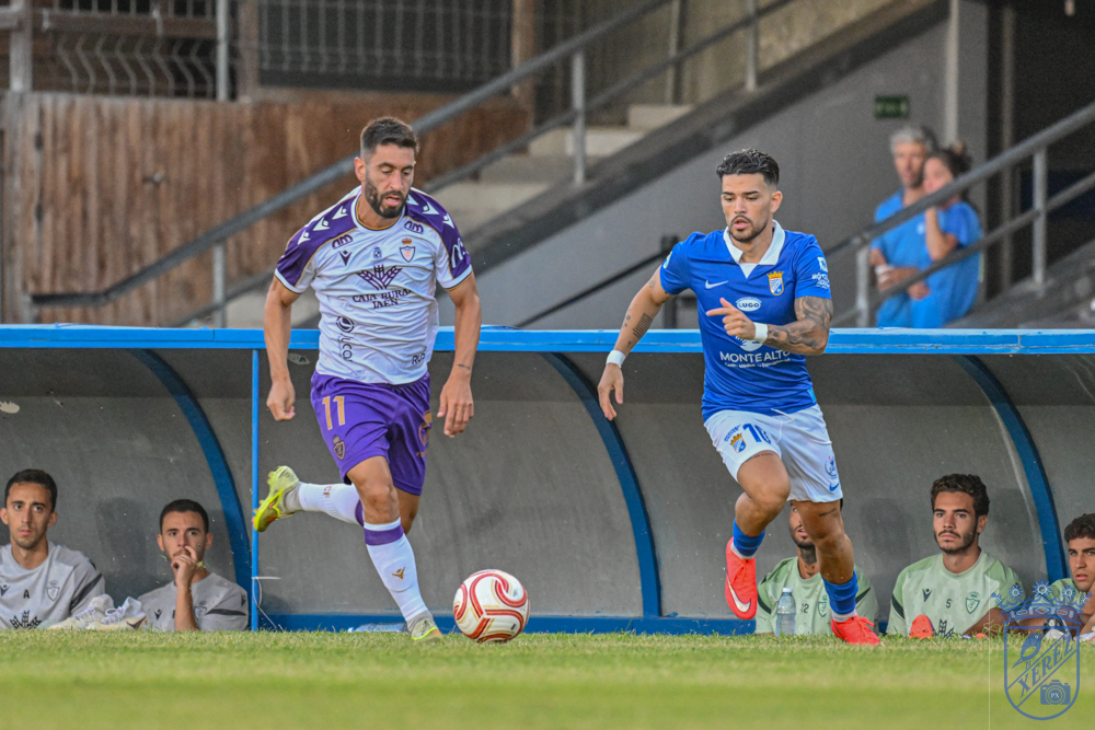 A Xerez CD player runs with the ball against a Real Jaén opponent at Chapín