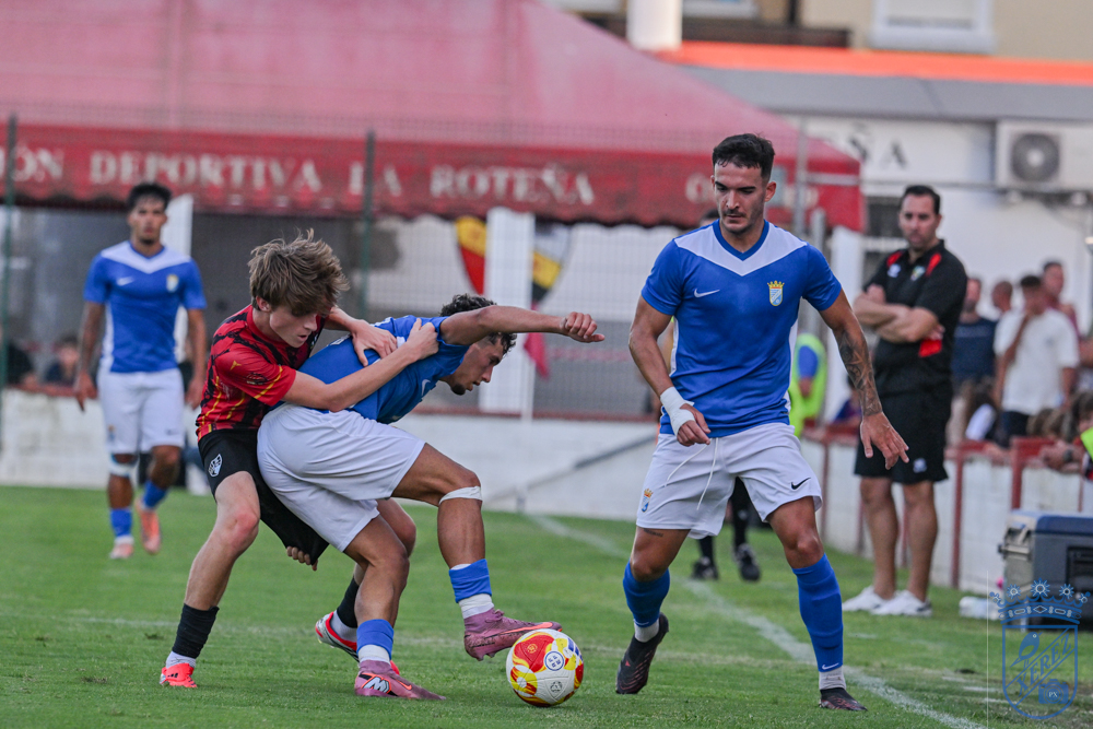 Un jugador del Xerez CD pugna por el balón con dos rivales de la UD Roteña en el Manuel Bernal