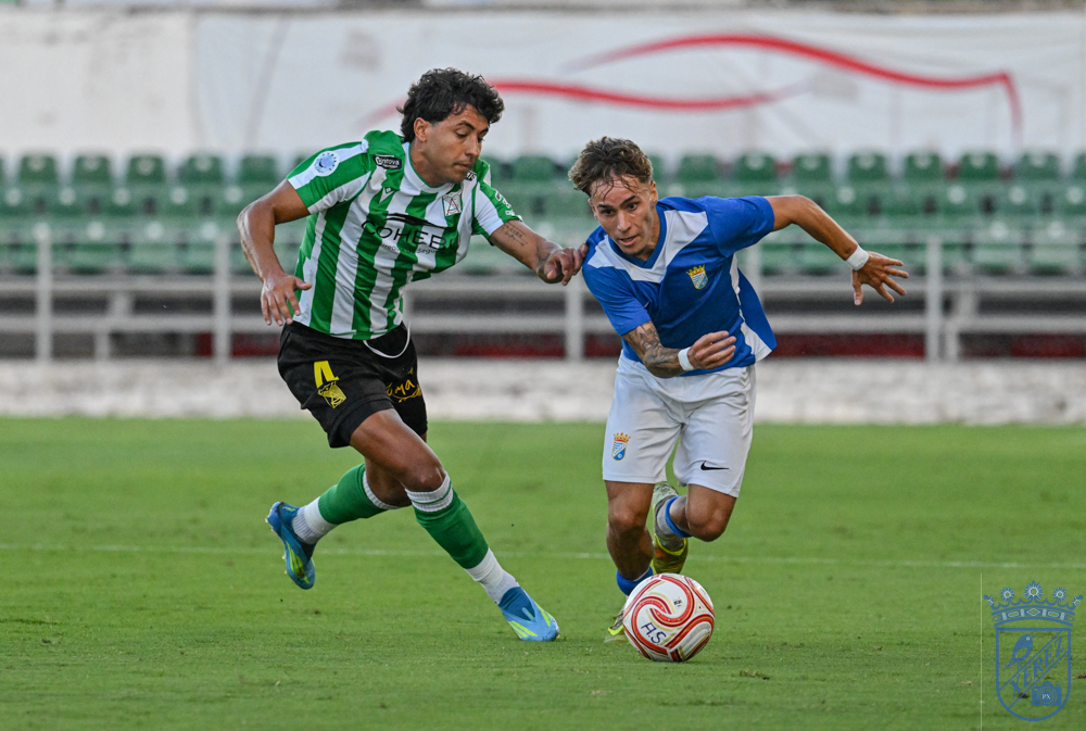 Un futbolista del Xerez CD conduce el balón ante la presión de un rival en El Palmar