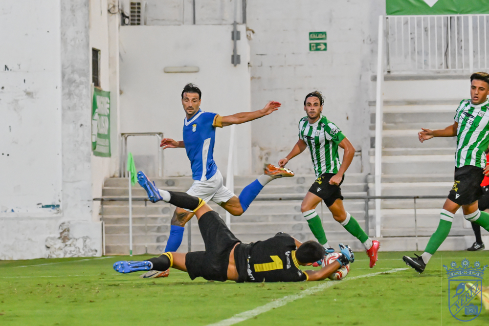 El guardameta del Atlético Sanluqueño se adelanta a un atacante azulino dentro del área