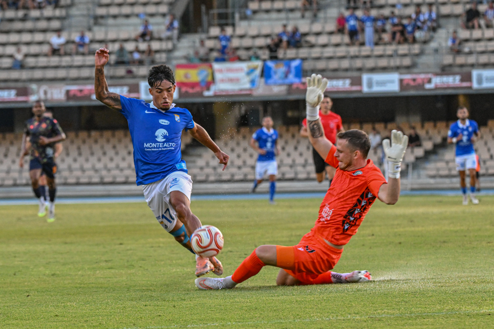 A Xerez CD player takes on the Juventud Torremolinos goalkeeper at Chapín