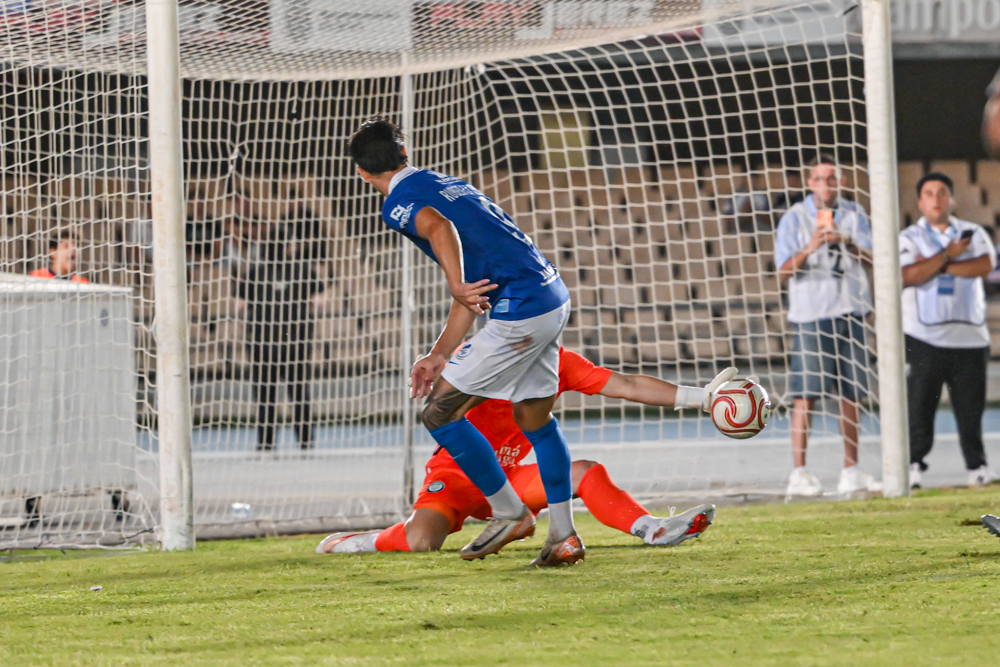 A Xerez CD player gets past the Juventud Torremolinos goalkeeper beside the goal at Chapín