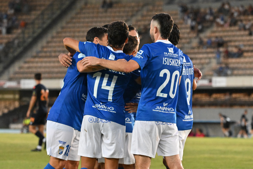 Xerez CD players embrace to celebrate Zelu's goal at Chapín
